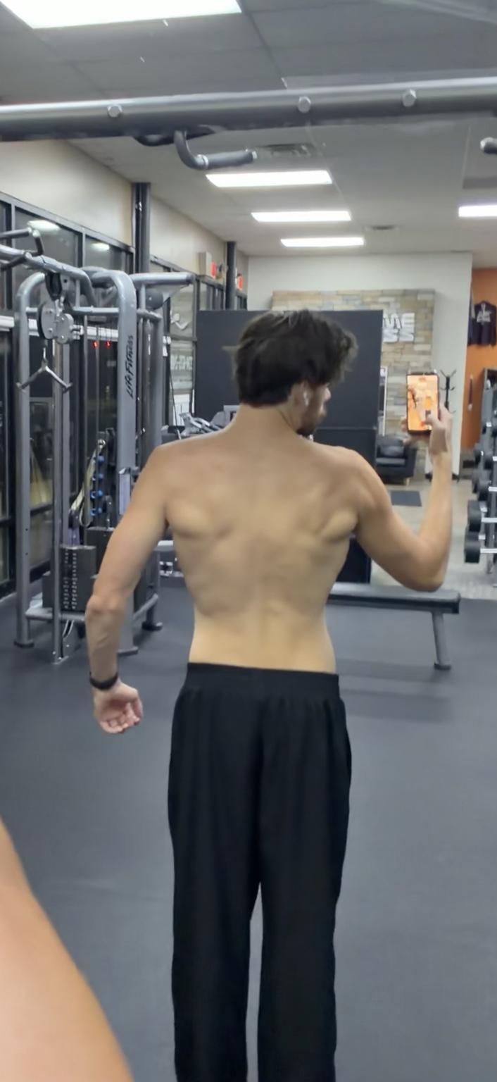 Current back physique photo of Greg at the gym